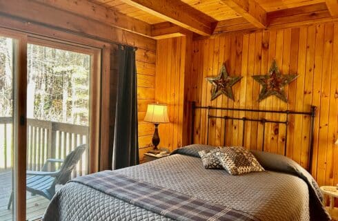 The Everett Room with queen bed, night stand looking our window at the Everett forest