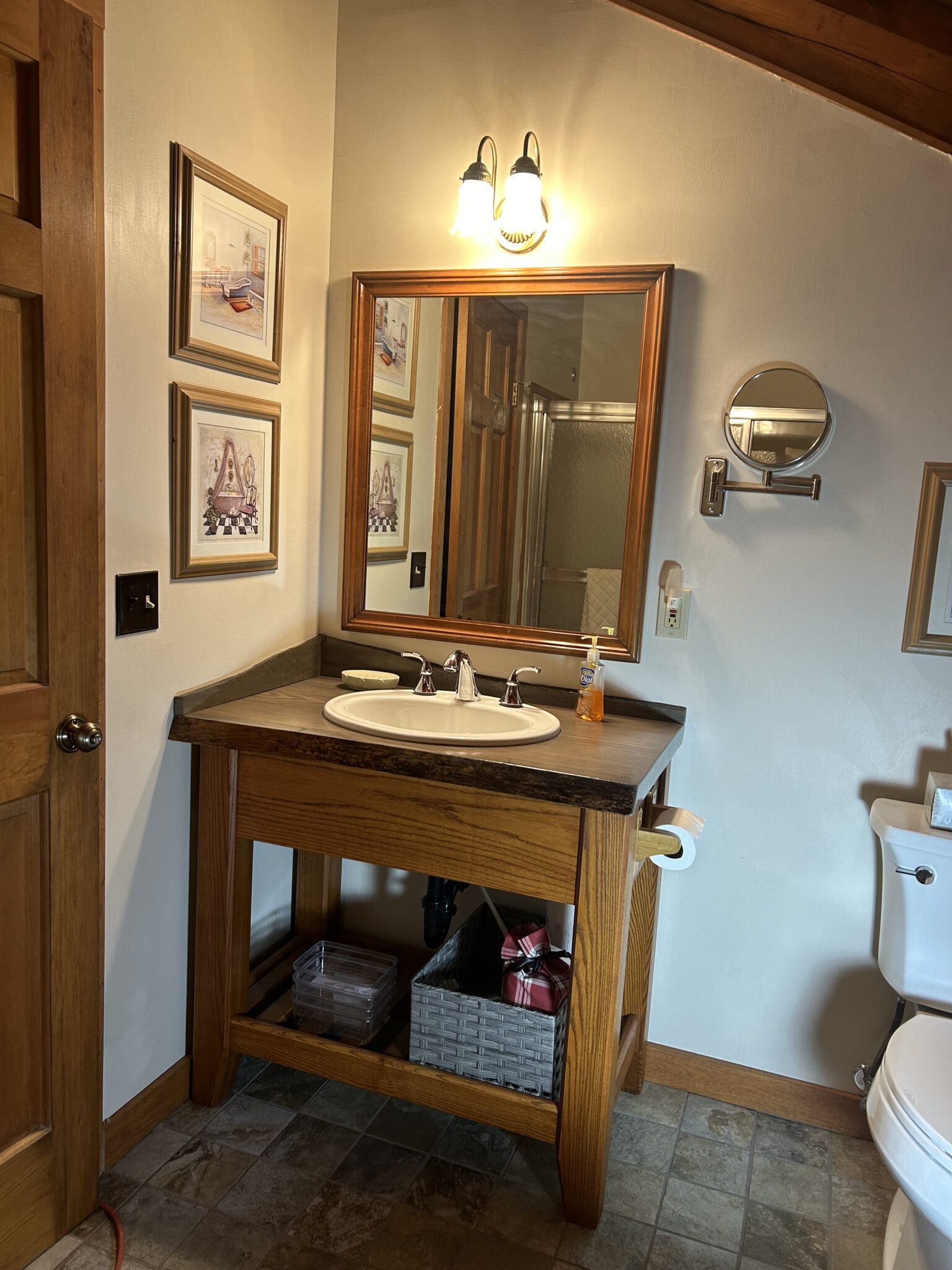 The newly renovated Shared bath has a new vanity with a solid wood counter, large mirror and a rustic porcelain floor.